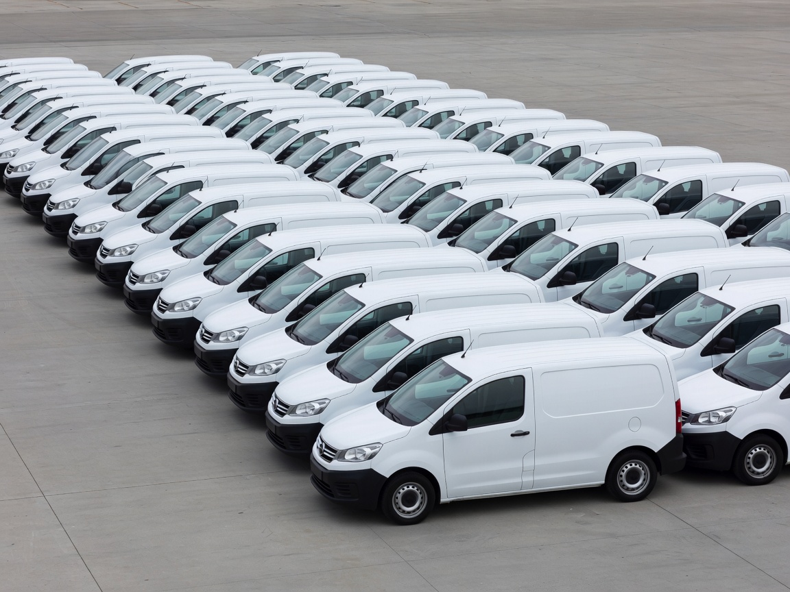 Organised fleet of small white commercial service vans parked neatly